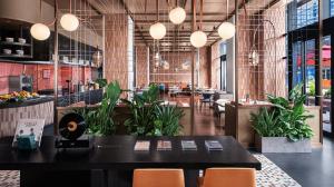a restaurant with a table and chairs and plants at 苏州云启一方酒店-凯悦尚选 in Suzhou