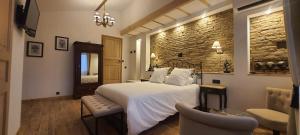 a bedroom with a large white bed and a chair at La Maison du Poelon in Labarthe-sur-Lèze