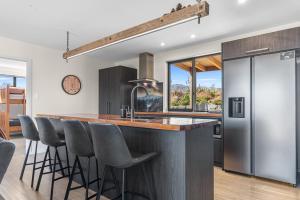a kitchen with a counter with bar stools at Sefton View in Lake Tekapo