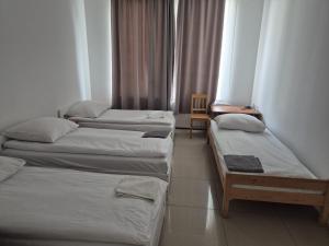 a group of three beds in a room at Hostel Wólka Kosowska z prywatnymi łazienkami in Wólka Kosowska