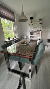 a dining room with a table and a green chair at Welkom op de Mildert in Nederweert