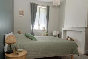 a bedroom with a green bed and a window at l atelier des etoiles in Haybes