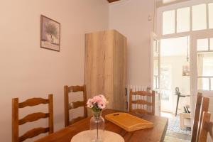 a dining room table with a vase of flowers on it at l atelier des etoiles in Haybes