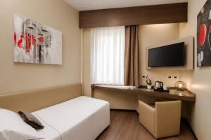 ein Hotelzimmer mit Bett und Fernseher in der Unterkunft Hotel Mentana, by R Collection Hotels in Mailand