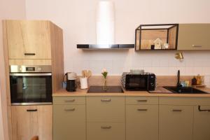a kitchen with a counter with a sink and a microwave at l atelier des etoiles in Haybes +10 photos