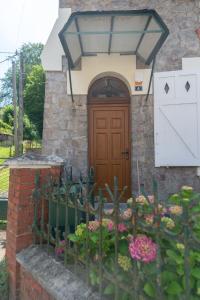 a house with a wooden door and some flowers at l atelier des etoiles in Haybes