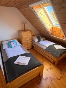a bedroom with two beds in a attic at Chalupa v prírode in Pliešovce