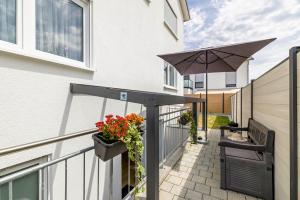 a balcony with an umbrella and flowers on a building at Apartment Dußlingen in Dußlingen