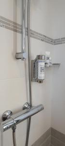 a bathroom with a shower with a metal shelf at La Maison du Poelon in Labarthe-sur-Lèze