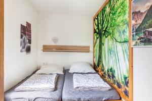 two beds in a room with a painting on the wall at Ferienhaus 35 in Zadelsdorf