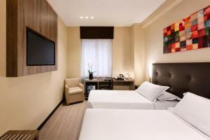 ein Hotelzimmer mit zwei Betten und einem Fernseher in der Unterkunft Hotel Mentana, by R Collection Hotels in Mailand