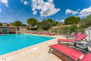 a swimming pool with red chairs and a swimming pool at Gite les Mazets du Rouret in Saint-Christol-lès-Alès