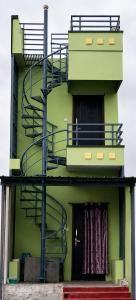 a green building with stairs on the side of it at D stays in Alāndurai