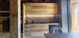 a kitchen with wooden cabinets and a counter top at DolomitiBel Siberiana 2 SILVER in Braz