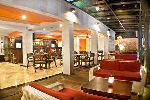 a restaurant with couches and tables and a dining room at Royal Regantris Kuta in Kuta