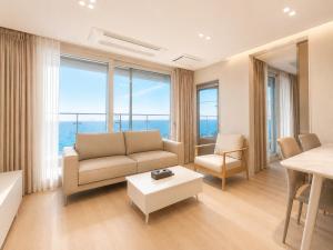 a living room with a couch and a table at Emerson Suites Naksan in Yangyang