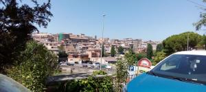 a view of a city with a blue car at Domus Mazzini in Tivoli