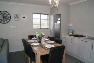a dining room table with chairs and a kitchen at Chalet Kudu in Ladismith