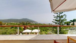 a balcony with umbrellas and a view of a city at Epidavros Villas - Gardenia Garden Retreat with Shared Pool in Nea Epidavros