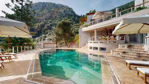 a pool at a hotel with a mountain in the background at Epidavros Villas - Gardenia Garden Retreat with Shared Pool in Nea Epidavros
