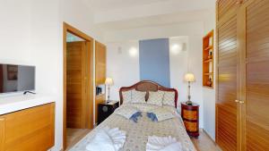 a small bedroom with a bed and a television at Epidavros Villas - Gardenia Garden Retreat with Shared Pool in Nea Epidavros +20 photos