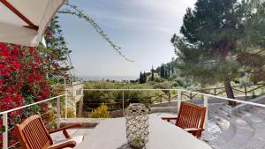 a table with a vase sitting on top of a balcony at Epidavros Villas - Elia Garden Retreat with Shared Pool in Nea Epidavros
