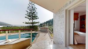 a house with a balcony with a swimming pool at Epidavros Villas - Elia Garden Retreat with Shared Pool in Nea Epidavros +18 photos