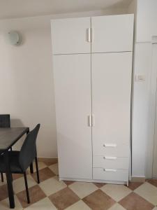 a large white cabinet in a room with a table at Apartma Studio Enej Piran in Piran
