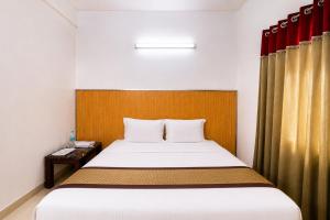 a bedroom with a bed with a wooden headboard at Luxe By Lotels in Chennai
