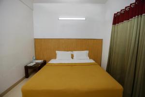 a bedroom with a large bed with a yellow blanket at Luxe By Lotels in Chennai +1 photo