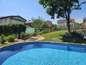 a large blue swimming pool in a yard with houses at Chalet Maier in Landschach