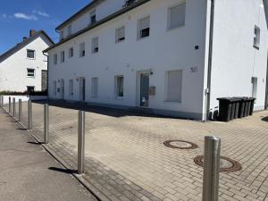 a white building with a row of poles in front of it at Team at Home Senden W2 in Senden