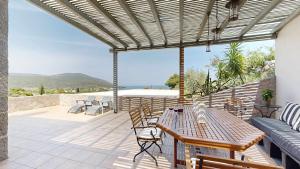 a patio with a table and chairs on a balcony at Epidavros Villas, Thymari Garden & Seaview Retreat in Nea Epidavros