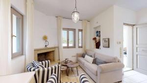 a living room with a couch and a fireplace at Epidavros Villas, Thymari Garden & Seaview Retreat in Nea Epidavros +25 photos