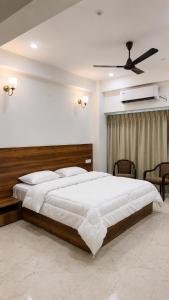 a bedroom with a large bed and a ceiling fan at Vortex Suites in Guwahati