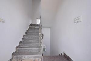 a stairway in a white building with a metal railing at Hotel O B.N.R. INN in Bangalore
