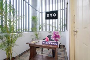a table in a room with plants and a sign at Hotel O B.N.R. INN in Bangalore