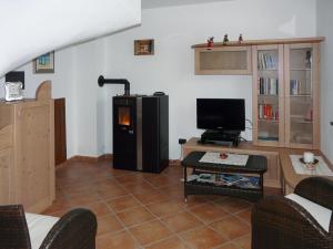 a living room with a tv and a couch and a table at Casa Vacanze IL BEARČ in Feltrone
