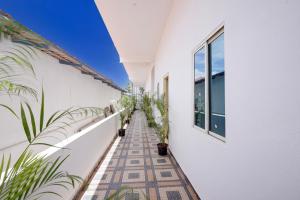 a balcony with potted plants and white walls at Hotel O B.N.R. INN in Bangalore
