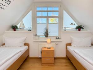 two beds in a room with two windows at Ferienhaus Meeresrauschen in Groß Kirr