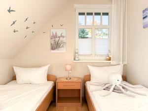 a bedroom with two beds and a window at Ferienhaus Meeresrauschen in Groß Kirr