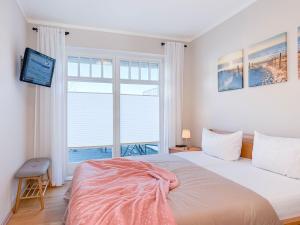 a bedroom with a large bed and a large window at Ferienhaus Meeresrauschen in Groß Kirr