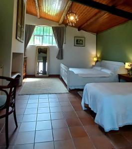 a bedroom with two beds and a large window at Giardino Antico in Montecarotto