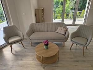 a living room with a couch and two chairs and a table at Villa Anna in Nowy Targ