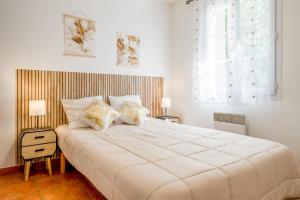 a white bedroom with a large bed and two lamps at Gite les Mazets du Rouret in Saint-Christol-lès-Alès +147 photos