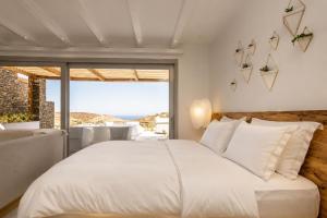 a bedroom with a bed and a large window at Elements Sifnos in Sifnos +94 photos
