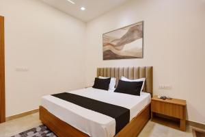 a bedroom with a bed and a painting on the wall at Hotel O Grace in Hānsi