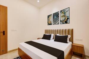 a bedroom with a bed with two pictures on the wall at Hotel O Grace in Hānsi