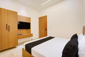 a bedroom with a bed and a flat screen tv at Hotel O Grace in Hānsi