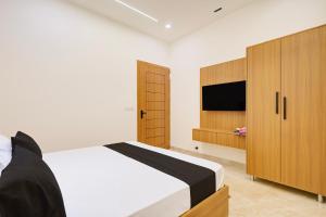 a bedroom with a bed and a tv and wooden cabinets at Hotel O Grace in Hānsi +35 photos